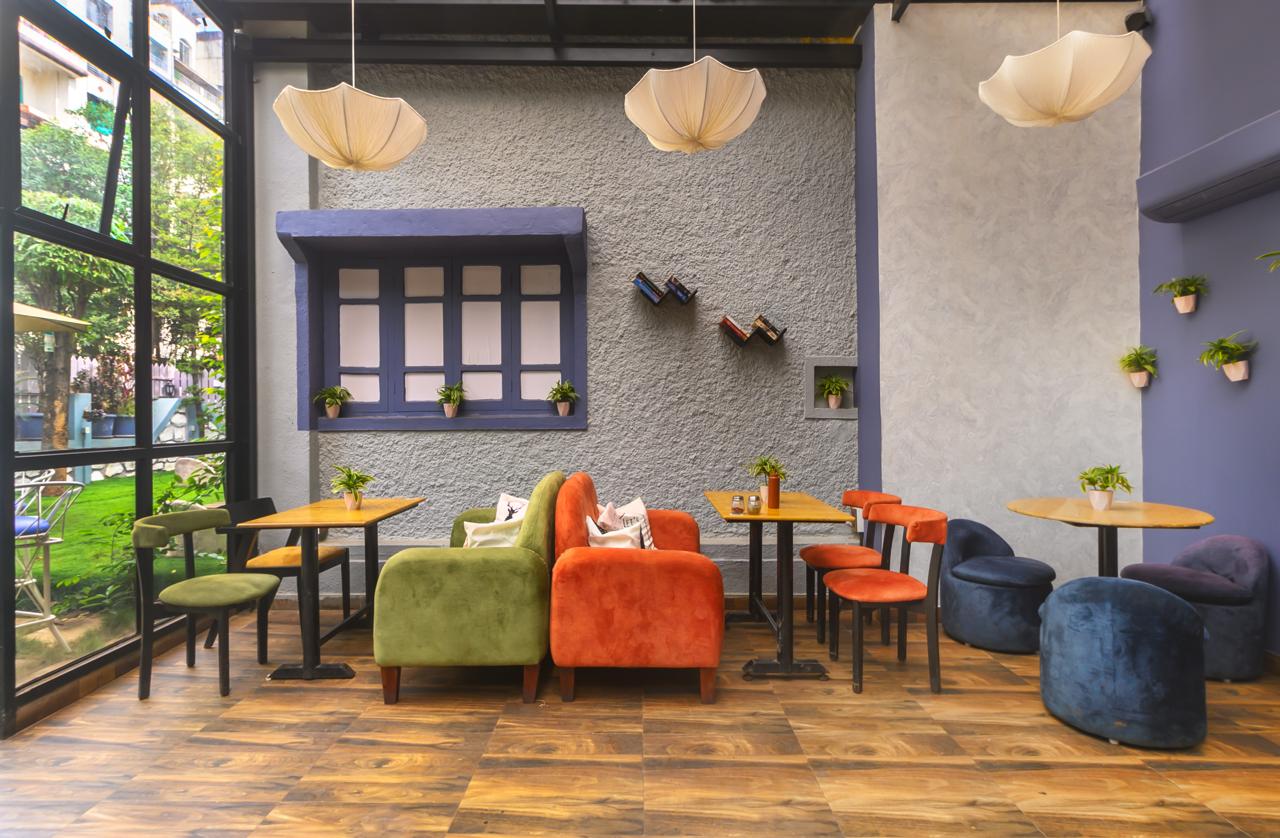 Eclectic cafe interior with colorful velvet sofas and unique umbrella lighting